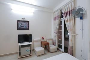 a room with a bed and a tv and chairs at Chim Go Kien Mini Hotel in Hue +34 photos