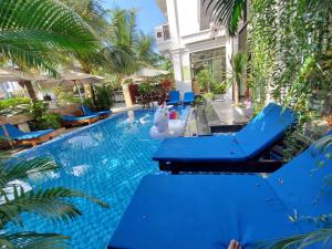 einem Pool mit blauen Stühlen und einem aufblasbaren Tier in der Mitte in der Unterkunft Hoi An Discovery Villa in Hoi An