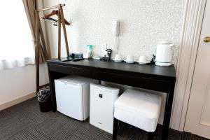 un bancone nero con due frigoriferi bianchi in una stanza di Stay Inn Will a Saitama