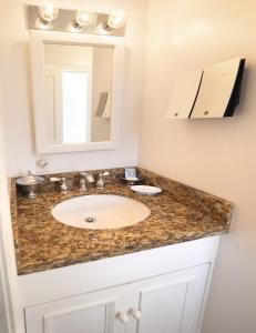 a bathroom with a sink and a mirror at The Gardens Hotel in Key West