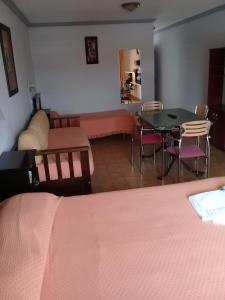 1 dormitorio con 1 cama, mesa y sillas en Apart Hotel Marilian en Salta