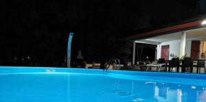 una piscina notturna con tavoli e sedie di B&B Vanessa House a Martellago