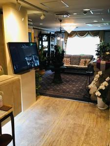 a living room with a couch and a tv at Hotel Star Dust (Adult Only) in Hiroshima