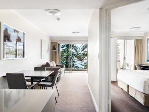 a bedroom with a bed and a table and chairs at Quest Manly in Sydney