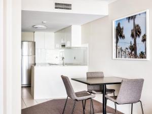 a kitchen and dining room with a table and chairs at Quest Manly in Sydney