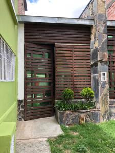 una puerta de madera de garaje en el lateral de una casa en ESTAR AQUI Bogotá, en Bogotá