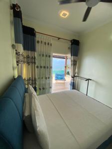 a bedroom with a bed with a view of the ocean at Che Beach House in Marang