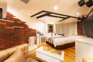 a hotel room with a bed and a brick wall at i RESORT ARTIA Sensual Gifu (Adult Only) in Ginan