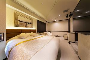 a bedroom with a large bed and a television at i RESORT ARTIA Sensual Gifu (Adult Only) in Ginan