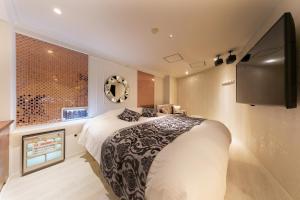 a bedroom with a large bed and a flat screen tv at i RESORT ARTIA Sensual Gifu (Adult Only) in Ginan +16 photos