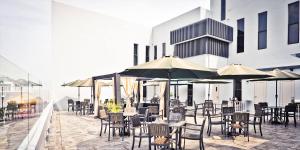 an outdoor patio with tables and chairs and umbrellas at Bei Boutique Hotel in Muar