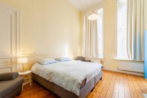 1 dormitorio con 1 cama grande y 1 sofá en Felix Delhasse, en Bruselas