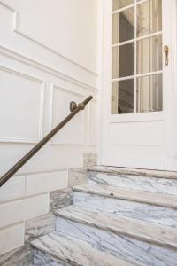 une main courante en métal sur une porte avec des escaliers dans l'établissement Felix Delhasse, à Bruxelles