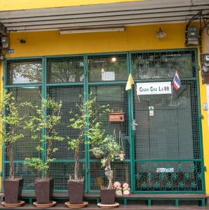 a store front with potted trees in front of it at Chan Cha La 99 Hostel in Bangkok