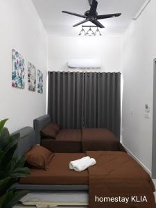 Un dormitorio con dos camas y un ventilador de techo. en Homestay KLIA Core Soho Suites, en Sepang