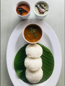 a plate of food with a bowl of soup and a plate of food at Dutch Bungalow in Cochin
