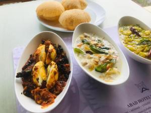 una mesa con tazones de comida y platos de comida en Dutch Bungalow en Kochi