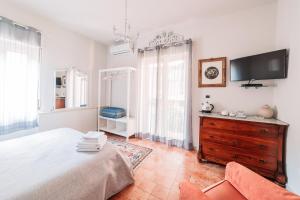 1 dormitorio con 1 cama, TV y vestidor en B&B Greco Home en Taormina