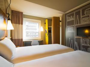 a hotel room with a bed and a tv at ibis Gent Centrum Opera in Ghent +62 photos