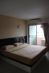 a bedroom with a large bed with a large window at Ladapan Mansion in Nonthaburi