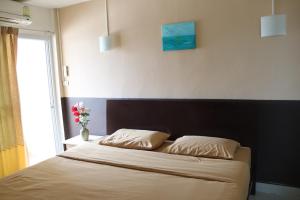 Un pat sau paturi într-o cameră la Ladapan Mansion