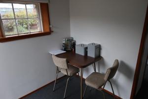 a small desk with two chairs and a window at The Tinkers Cottage in Clyde
