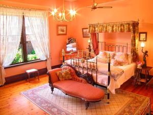 um quarto com uma cama, uma cadeira e um lustre em Buxton Manor em Adelaide