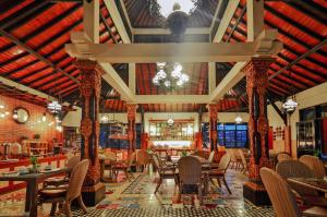 a restaurant with tables and chairs and a chandelier at Ari Putri Hotel in Sanur
