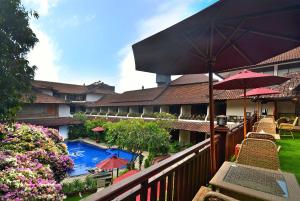 a balcony of a resort with a swimming pool and umbrellas at Ari Putri Hotel in Sanur