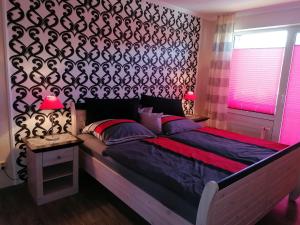a bedroom with a large bed with a black patterned wall at Lagunenstadt Ueckermünde in Ueckermünde