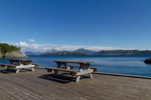 
a row of wooden benches sitting on top of a beach at Florø Rorbu in Florø
