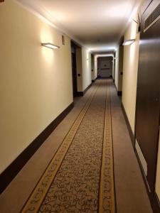 um longo corredor com uma linha amarela no chão em Vercelli Palace Hotel em Vercelli