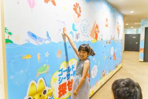 a young girl standing in front of a wall in a room at Hotel Ocean (Kokusai-Dori) in Naha