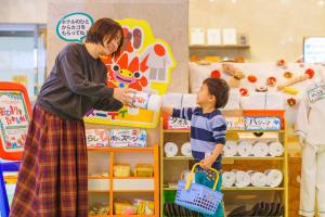 a woman giving a child a bottle of milk at Hotel Ocean (Kokusai-Dori) in Naha