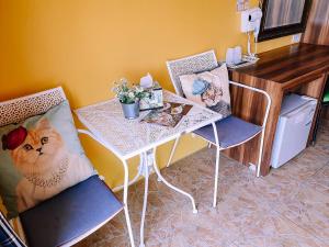 een tafel en stoelen met een kat in een kamer bij The Castello Resort in Ko Larn