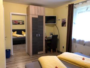 Zimmer mit einem Schlafzimmer mit einem Bett und einem Schreibtisch in der Unterkunft Pension Elan in Bayerisch Eisenstein