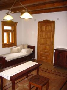 a room with a bed and a table and a door at Birsalma Vendégház in Markaz