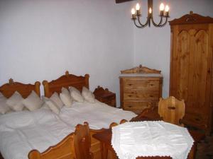 1 dormitorio con 2 camas, mesa y cómoda en Birsalma Vendégház, en Markaz