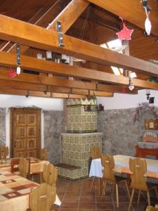 a room with wooden tables and chairs and a fireplace at Birsalma Vendégház in Markaz
