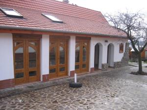 a building with wooden doors and a red roof at Birsalma Vendégház in Markaz