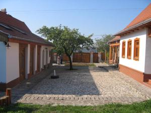 a courtyard between two buildings with a tree in the middle at Birsalma Vendégház in Markaz