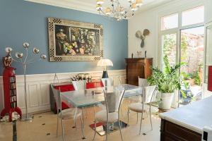 a dining room with a glass table and chairs at Demeure Belle Epoque in Reims