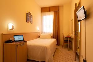 Un pat sau paturi într-o cameră la Hotel Mirandola