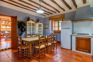 una cucina con tavolo, sedie e frigorifero di Cortijo Fuente de Alonso Gomez ad Archidona