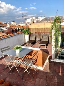 un patio con mesa y sillas en la azotea en Apartamentos Puerta Del Sol, en Madrid