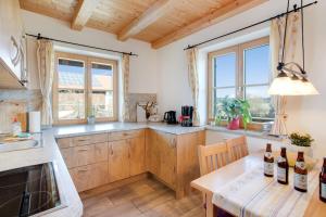 a kitchen with wooden cabinets and windows and a table at Ferienwohnung Seeblick in Bad Heilbrunn