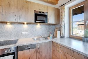 a kitchen with a sink and a microwave at Ferienwohnung Seeblick in Bad Heilbrunn +12 photos