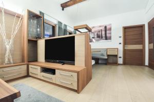 a living room with a large entertainment center with a flat screen tv at Apt Hetti - Haus Kostner in Santa Cristina Gherdëina