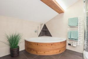 bagno con ampia vasca in legno in una stanza di Apt Hetti - Haus Kostner a Santa Cristina in Val Gardena Altre 19 foto