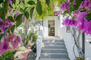 a staircase leading up to a white house with purple flowers at La Lujancita in Puerto del Carmen